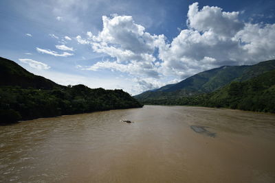 Scenic view of river amidst mountains against sky