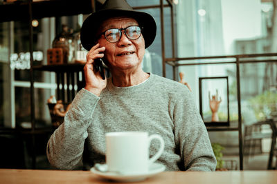 Man holding coffee cup in restaurant