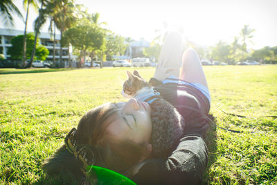 Rear view of a cat lying on field