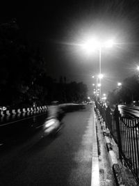 Cars on illuminated street at night