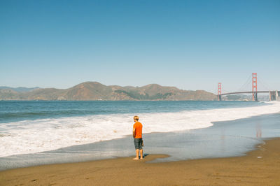 Rear view of woman standing on beach