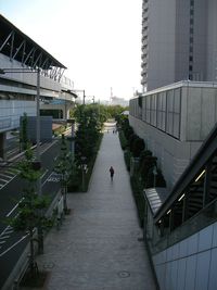 People walking on footpath amidst buildings in city