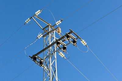 Low angle view of electricity pylon against sky