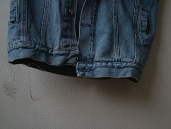 Close-up of jeans hanging against wall