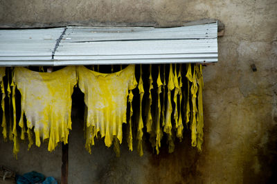 Close-up of yellow clothes hanging on wall