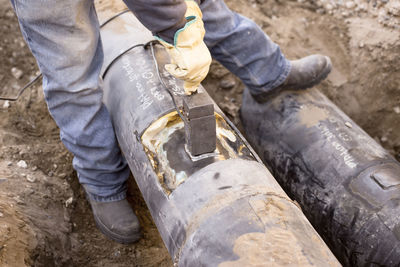 Low section of man working on metal