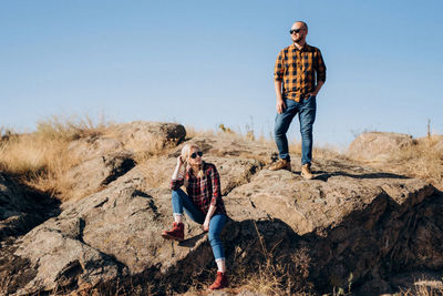 Full length of friends standing on rock