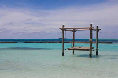 Lifeguard hut on beach against blue sky