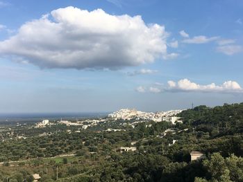 Aerial view of city by sea against sky