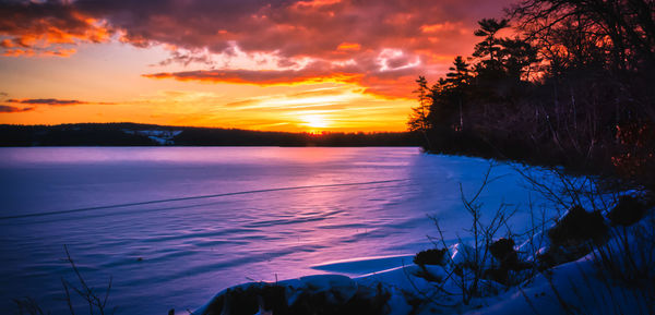 Scenic view of lake against romantic sky at sunset