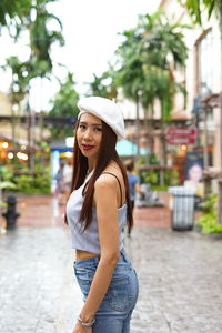 Portrait of beautiful woman standing on footpath 