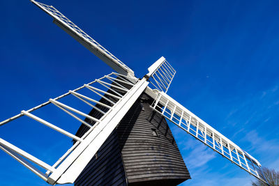 Low angle view of traditional windmill against clear blue sky