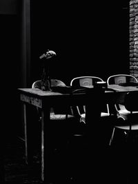 Empty chairs and table against window