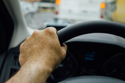 Cropped hand of man driving car