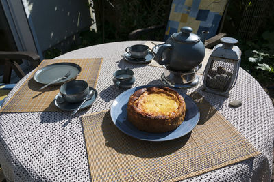 The table on the terrace is set. the blue tea set, plates, cups and the delicious cake.i summer day.