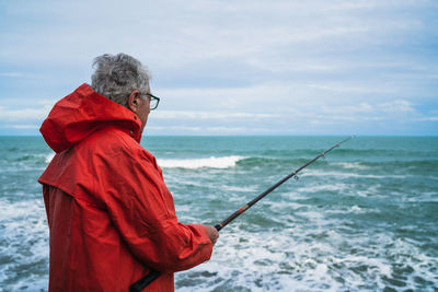 Man standing in sea against sky