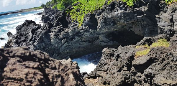 Rock formations by sea against sky