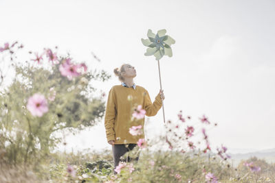 Young woman with pinwheel in cottage garden