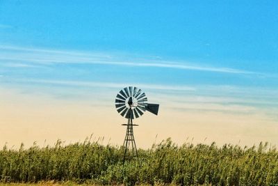 Windmill on field against sky