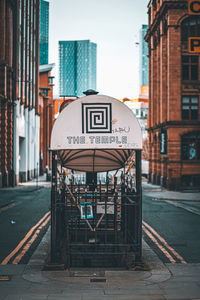 Road sign on street by buildings in city