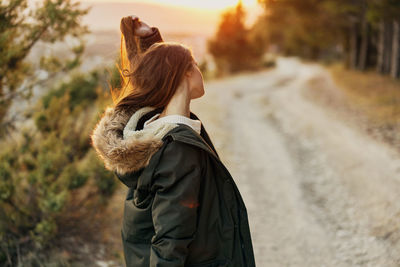 Side view of young woman standing in winter