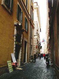 People on street amidst buildings in city