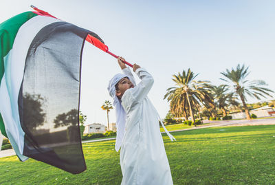

boy holding united arab emirates flag at park