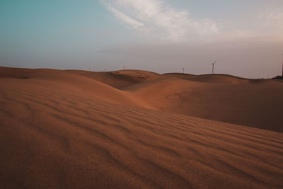 Sand dunes in desert against sky