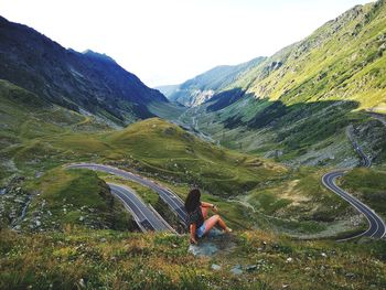 Rear view of woman looking at mountain range against sky