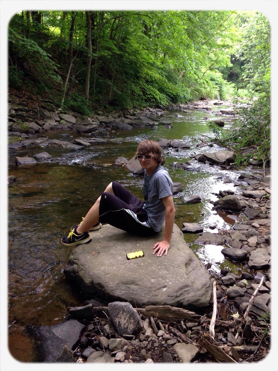 lifestyles, leisure activity, transfer print, full length, water, rock - object, casual clothing, auto post production filter, sitting, person, tree, young adult, forest, vacations, river, young men, rock