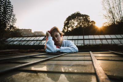 Young woman relaxing on railing against clear sky