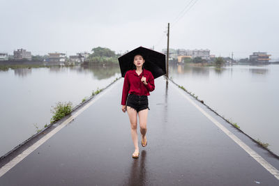Full length portrait of woman standing on water