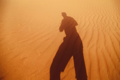 Shadow of man on sand dune