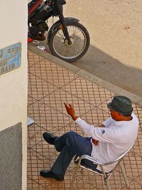 High angle view of man sitting outdoors