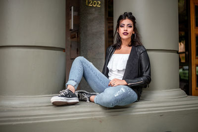 Portrait of young woman sitting on floor at home