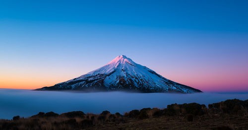 Scenic view of snow covered mountains against clear sky