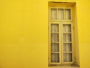 Closed door of yellow wall of building