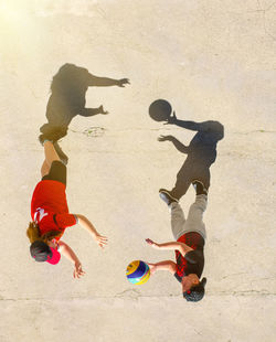 High angle view of siblings playing with ball on land