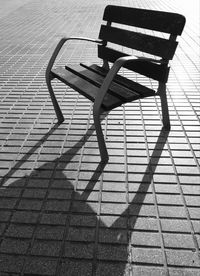 High angle view of bench on sidewalk