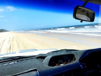Car on beach against sky