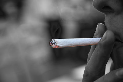 Midsection of person holding cigarette