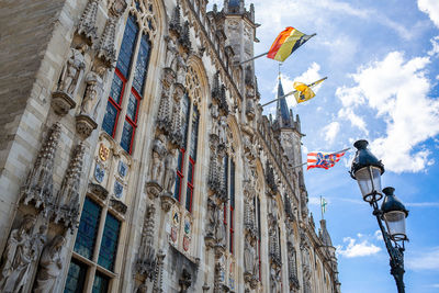 Low angle view of flags on building against sky