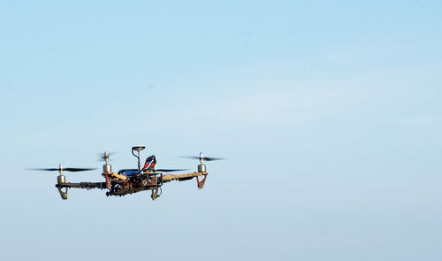 Quadcopter flying in clear blue sky