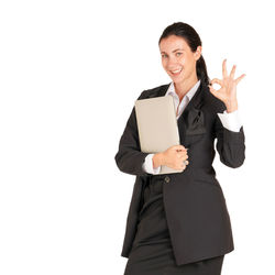 Smiling young woman standing against white background