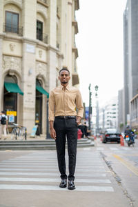 Full length portrait of man standing on street in city