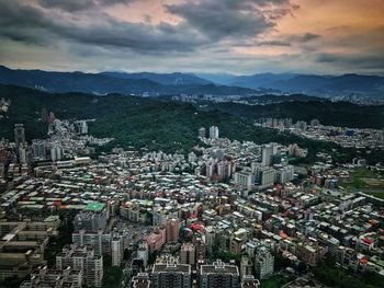 High angle view of cityscape against cloudy sky