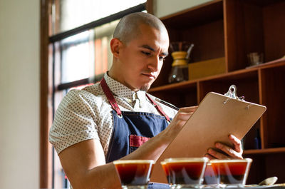 Man looking away while sitting on table at home