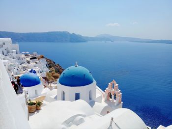 Scenic view of village, dome and sea against sky