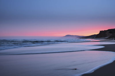 Scenic view of beach against sky during sunset