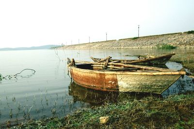 Boats moored in lake against sky